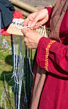 Woman working on a small medieval loom