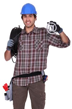 An electrician holding a at sign.