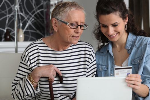 grandma and home helper with laptop