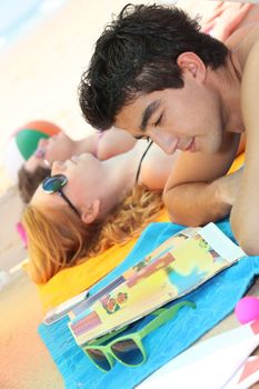 Thee friends laid on a beach