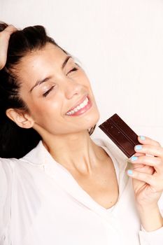 Portrait of a beautiful, latin Woman eating chocolate.