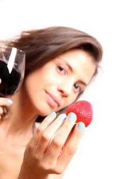 Portrait of a beautiful, latin Woman eating a Strawberry and drinking wine.