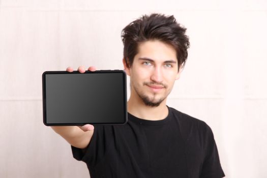 A young hispanic man holding a Tablet PC.