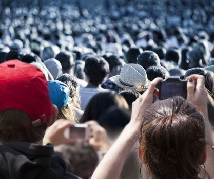 Large crowd of people watching concert or sport event