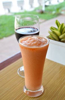 fresh tropical papaya and pineapple smoothie in front of wine glass