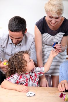Family playing with a boy's toy cars