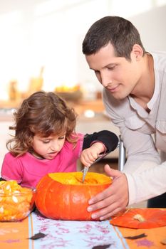 Father and daughter carving pumpkins