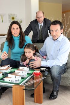 Architect with a family looking at a construction model