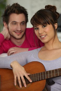 Girlfriend playing the guitar for her boyfriend