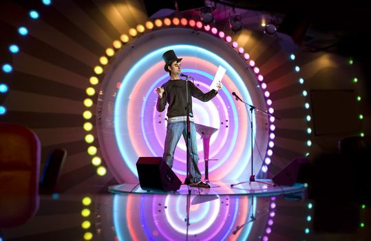 comedian with tile on stage of studio makes laugh of comedy show