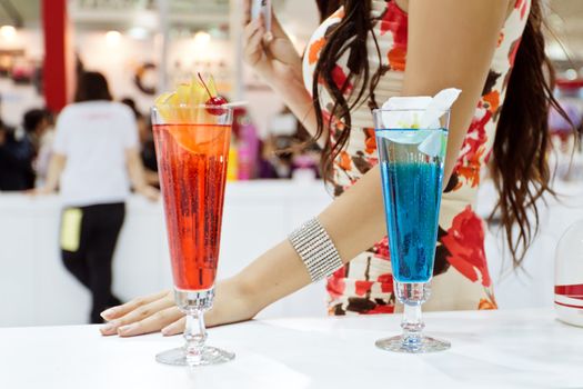 Two cocktails (Blue Laguna and Eliza) with a sexy girl on background