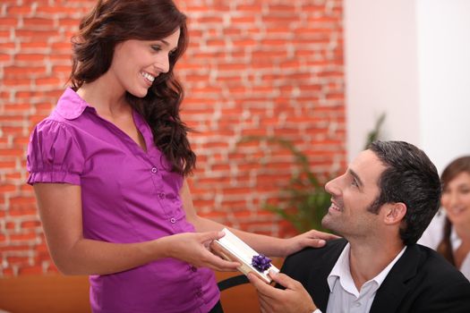 Woman offering man a small gift