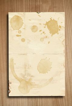 Vintage paper with coffee stains on wooden background