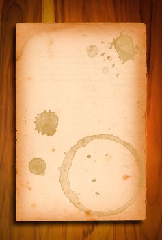 Vintage paper with coffee stains on wooden background