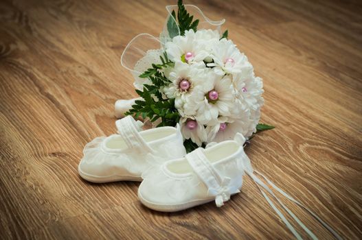 white shoes and white bouquet on a wooden floor