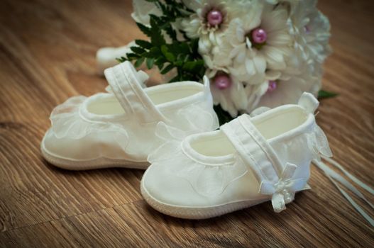 white shoes and white bouquet on a wooden floor