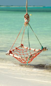 Hammock Rope Swing in tropical environment on ocean beach background