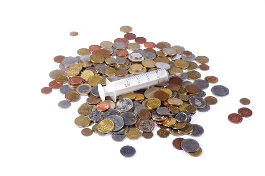 Coins from many countries and disposable syringe 