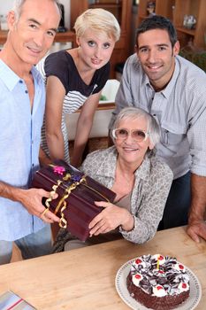 family celebrating mother's birthday, she's about 70 years old