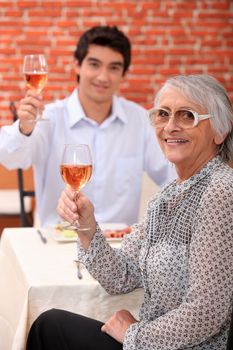 Grandmother and young man drinking rose wine