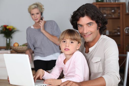 Family in kitchen with laptop