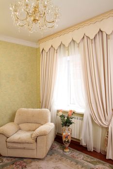 beautiful interior with a chair about a window with a curtain, a vertical shot