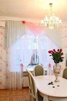 beautiful interior of kitchen with a dining table and a window with a curtain, a vertical shot