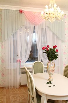 beautiful interior of kitchen with a dining table and a window with a curtain, a vertical shot, a double 2