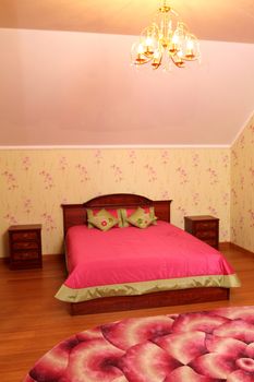 beautiful interior of a bedroom with a bed, a chandelier and a carpet