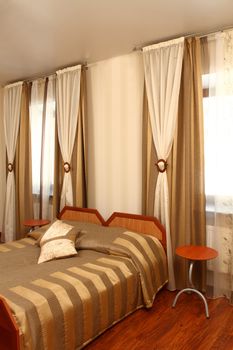 beautiful interior of a bedroom with a bed and a window with a beautiful curtain, a vertical shot