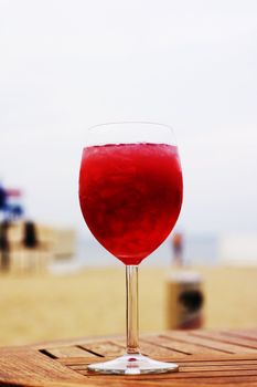 red drink with ice on the beach