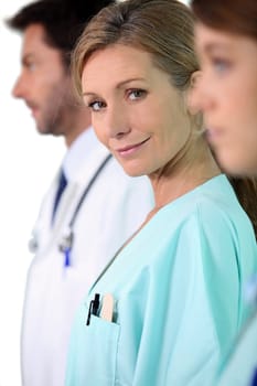 Female nurse standing in the middle of two colleagues