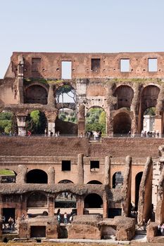 A Coloseum ruins with tourists in Rome
