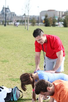 couple with personal trainer in park