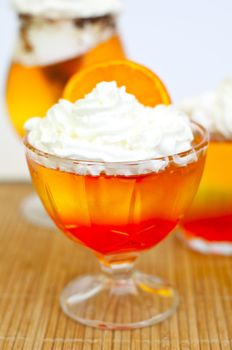 tricolor jelly with whipped cream in a glass 