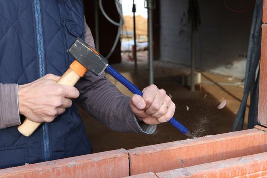 Man using hammer and chisel on wall