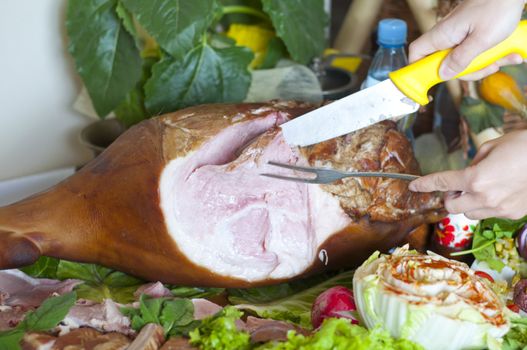 a woman cuts off a chunk of ham