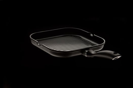 new pan with grill over black background