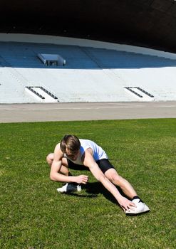 Runner at the city stadium warming and stretching
