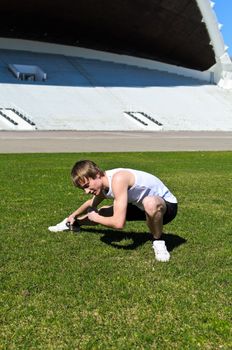 Runner at the city stadium warming and stretching