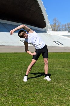 Runner at the city stadium warming and stretching