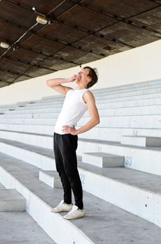 Athletic male yawning on empty sport stadium