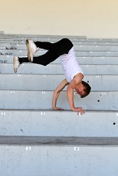Portrait of athletic male doing flip on empty stadium