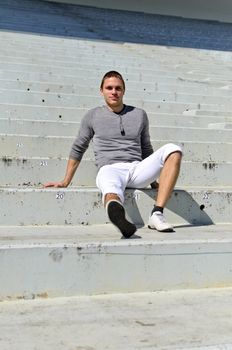 Young athletic guy in an empty stadium