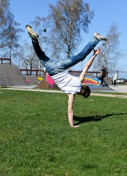 Breakdancer doing a flip on the grass.
