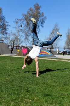 Breakdancer doing a flip on the grass.