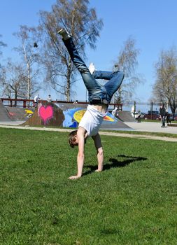 Breakdancer doing a flip on the grass.
