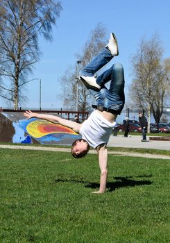 Breakdancer doing a flip on the grass.