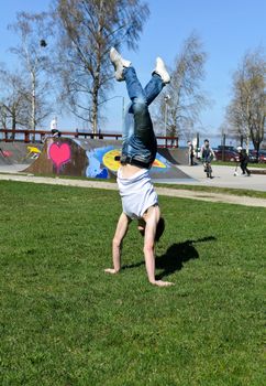 Breakdancer doing a flip on the grass.