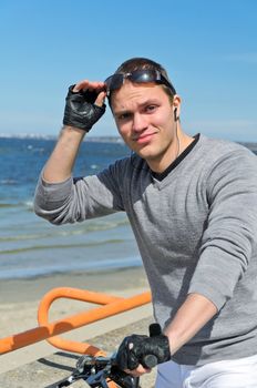 Portrait of handsome male with bicycle by the sea